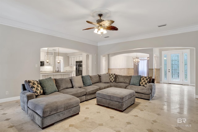 living room featuring ceiling fan with notable chandelier and ornamental molding