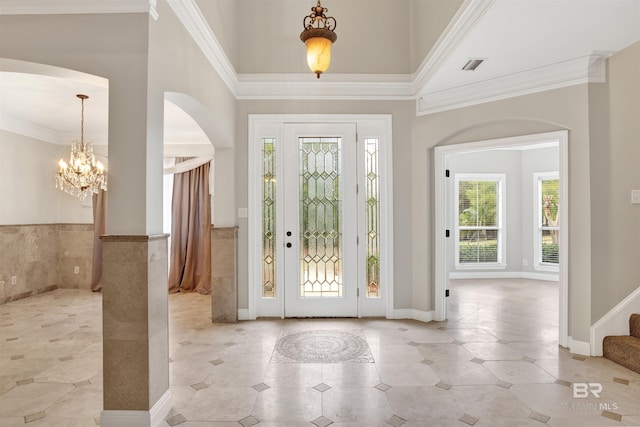 entryway featuring ornamental molding and a notable chandelier