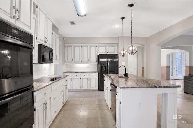 kitchen featuring white cabinets, sink, a kitchen island with sink, and black appliances