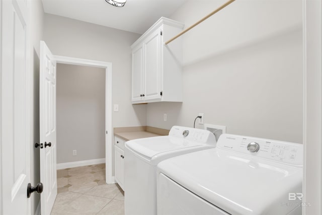 washroom with cabinets, washer and clothes dryer, and light tile patterned flooring