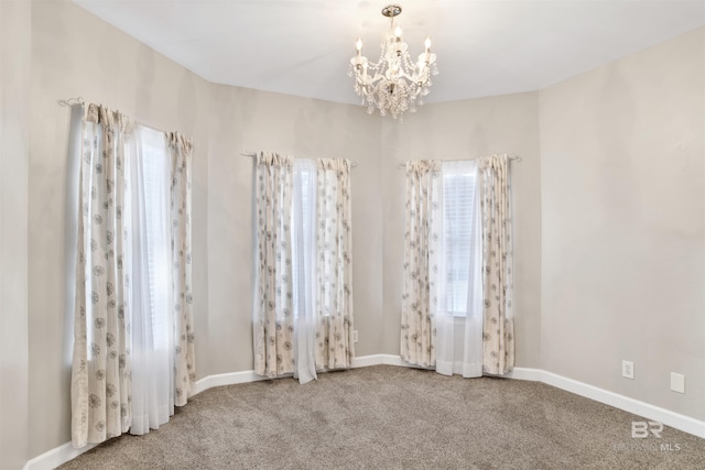 unfurnished room with carpet floors and an inviting chandelier