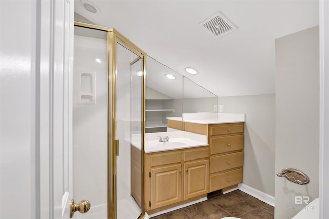 bathroom with a shower with door, vanity, and tile patterned flooring