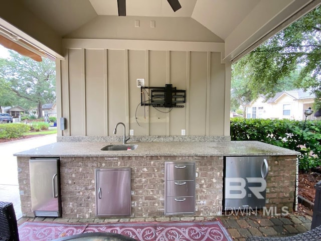 view of patio featuring exterior kitchen and a sink