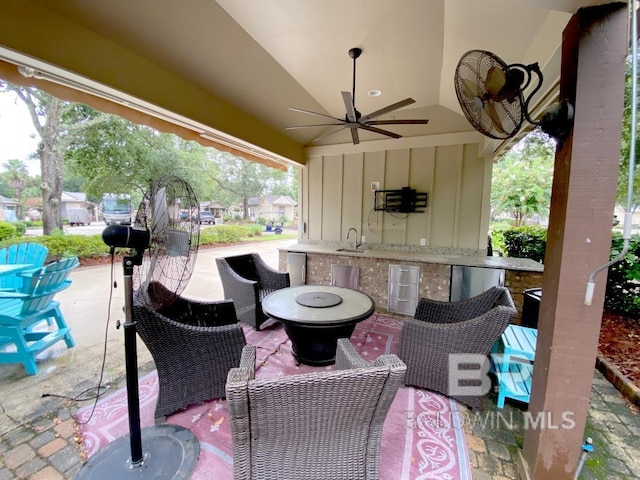 view of patio / terrace with outdoor wet bar, area for grilling, and a ceiling fan