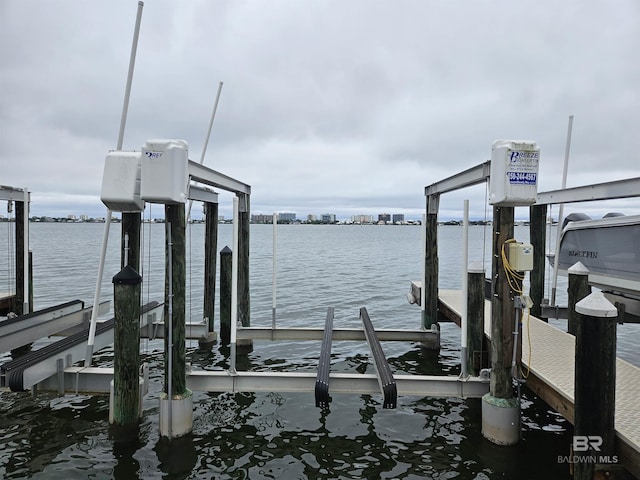 dock area featuring boat lift and a water view
