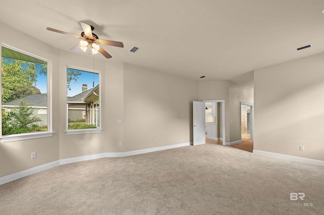 spare room featuring light colored carpet and ceiling fan