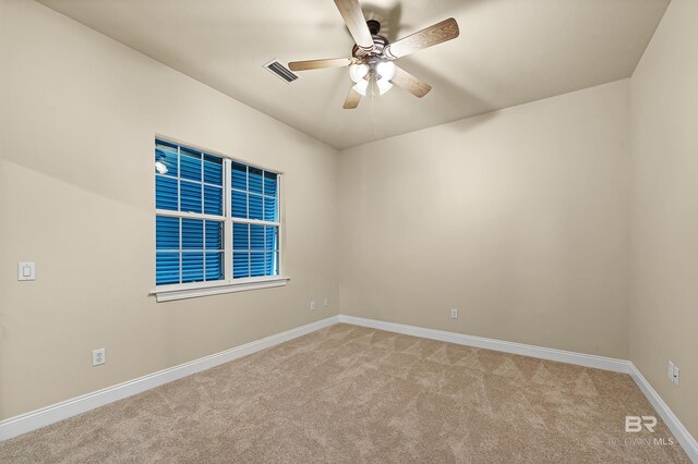 carpeted spare room featuring ceiling fan