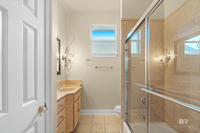 bathroom featuring vanity, toilet, plenty of natural light, and a shower with door