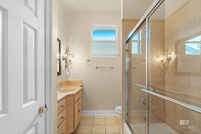 36 Lagoon Dr, Gulf Shores, AL 36542 - bathroom with vanity, baseboards, tile patterned floors, a healthy amount of sunlight, and a shower with shower door