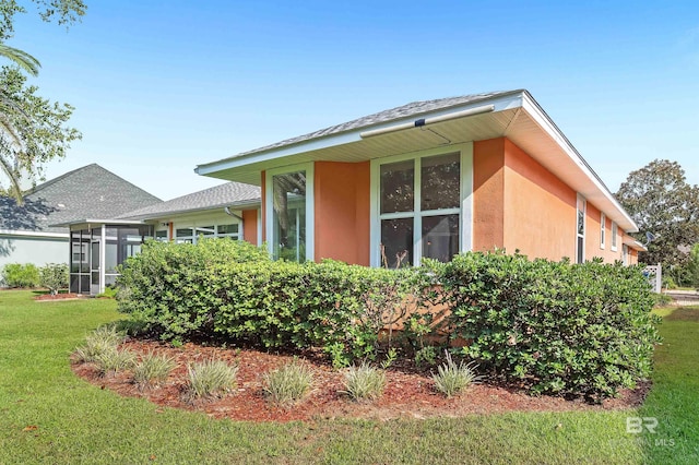 view of home's exterior featuring a sunroom and a yard