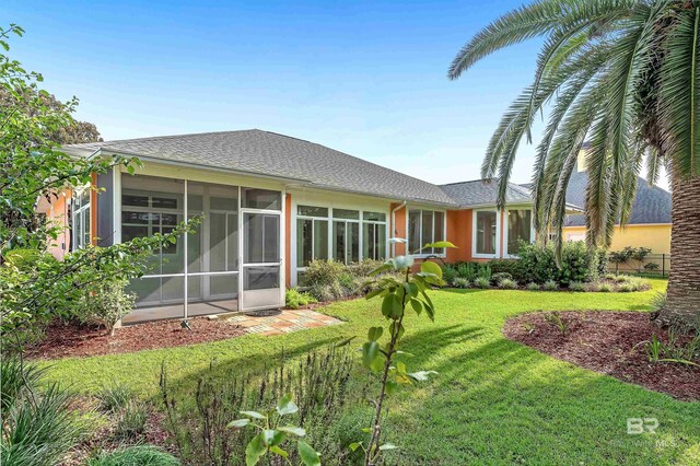 36 Lagoon Dr, Gulf Shores, AL 36542 - back of house featuring a yard, stucco siding, a sunroom, and roof with shingles