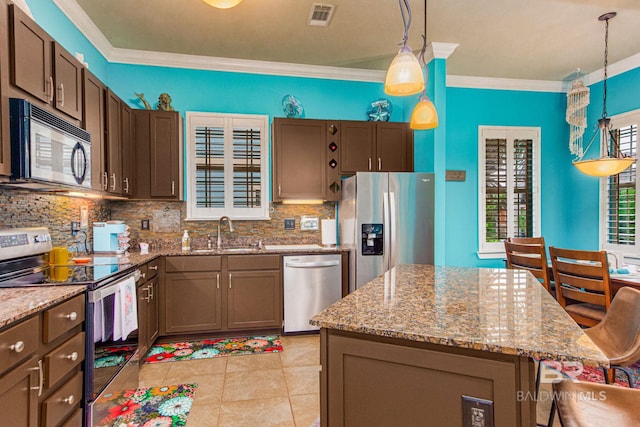 kitchen with crown molding, a center island, stainless steel appliances, and sink