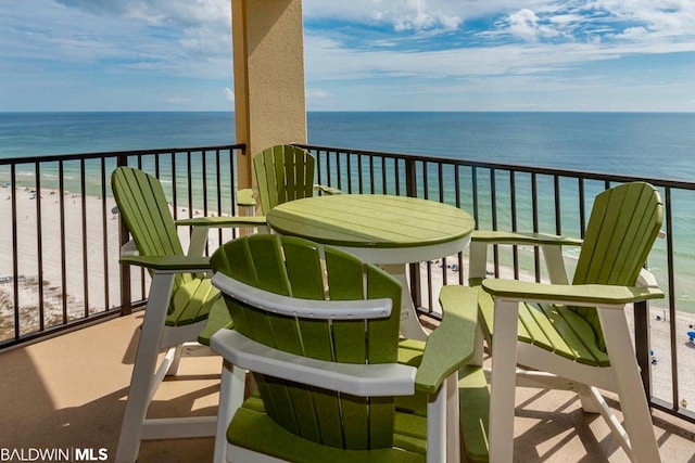 balcony featuring a water view and a beach view