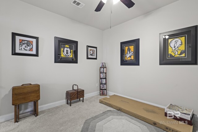 living area with ceiling fan and light carpet