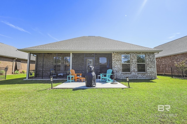 back of house with a lawn, a sunroom, and a patio