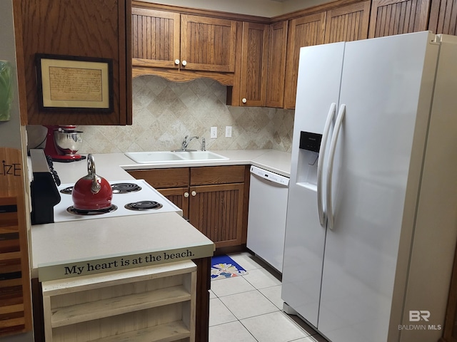 2200 W 2nd St Unit B-106, Gulf Shores, AL 36542 - kitchen featuring white appliances, a sink, backsplash, brown cabinetry, and light countertops