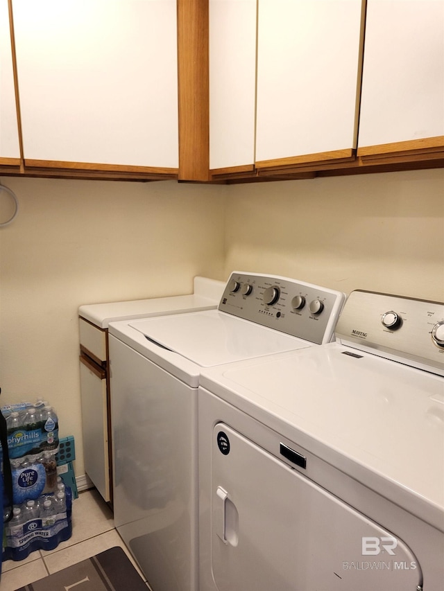 2200 W 2nd St Unit B-106, Gulf Shores, AL 36542 - clothes washing area featuring washing machine and dryer, light tile patterned flooring, and cabinet space