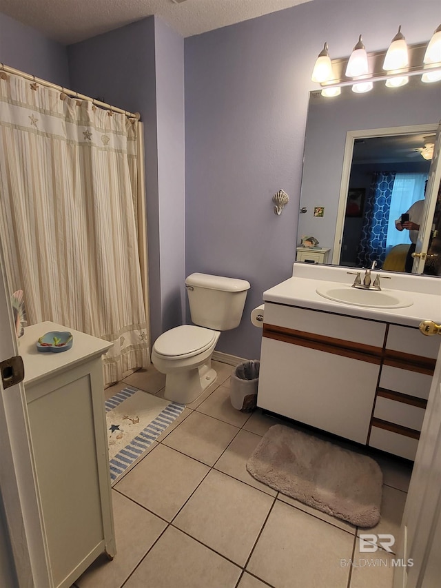 2200 W 2nd St Unit B-106, Gulf Shores, AL 36542 - bathroom with tile patterned floors, toilet, vanity, a textured ceiling, and a shower with curtain