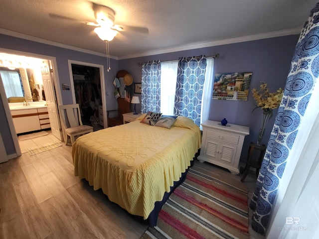 2200 W 2nd St Unit B-106, Gulf Shores, AL 36542 - bedroom featuring ornamental molding, light wood-style floors, connected bathroom, ceiling fan, and a sink