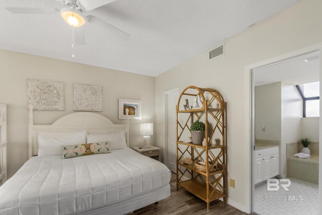 bedroom with ensuite bath, visible vents, and a ceiling fan