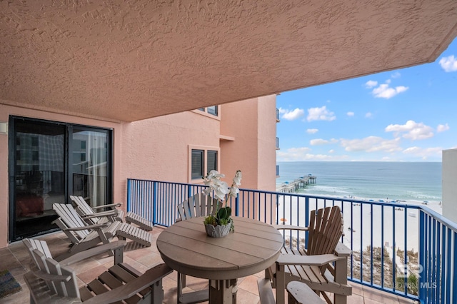 balcony featuring a beach view and a water view