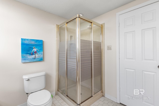 bathroom with toilet, baseboards, tile patterned flooring, and a stall shower