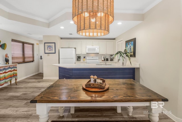 dining room with recessed lighting, light wood finished floors, baseboards, and ornamental molding