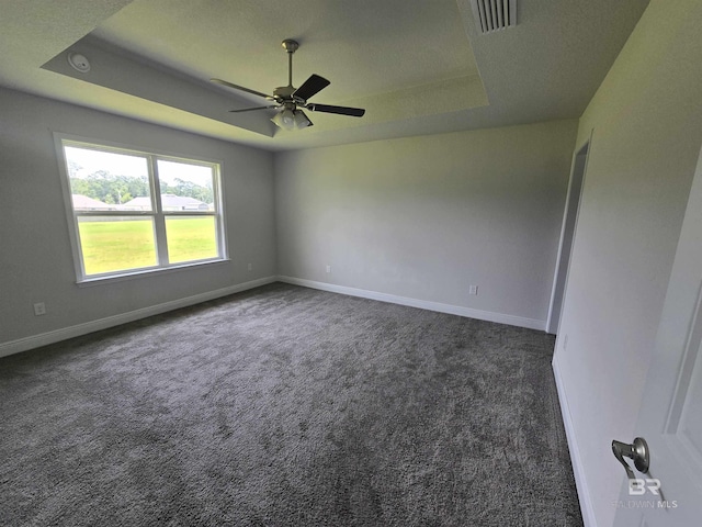 23035 Ridgewood Dr, Robertsdale, AL 36567 - unfurnished room with a tray ceiling, dark carpet, a ceiling fan, and a smoke detector