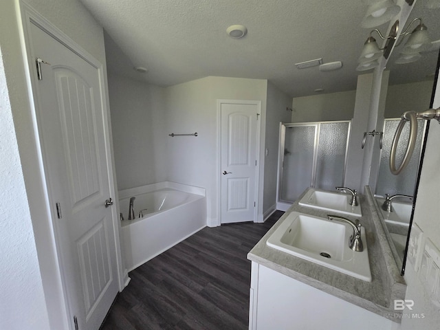 23035 Ridgewood Dr, Robertsdale, AL 36567 - bathroom with a garden tub, a shower stall, double vanity, wood finished floors, and a textured ceiling