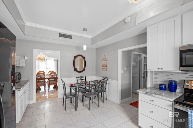 dining area featuring a raised ceiling, marble finish floor, a chandelier, and visible vents