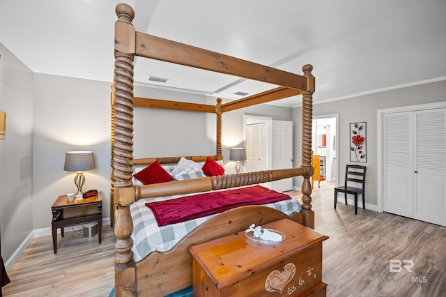 bedroom featuring baseboards, ornamental molding, wood finished floors, and visible vents