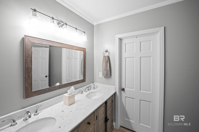 bathroom with a sink, ornamental molding, and double vanity