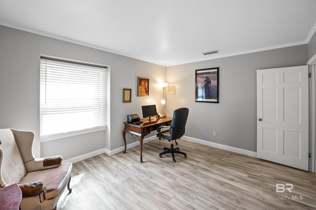 office with baseboards, visible vents, ornamental molding, and light wood finished floors