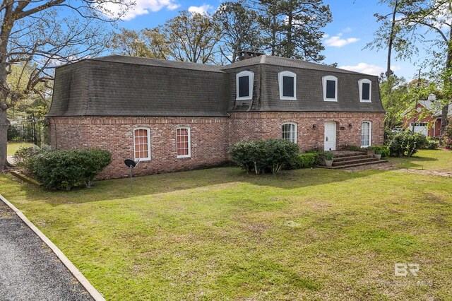 803 S Pensacola Ave, Atmore, AL 36502 - view of front of home with roof with shingles, mansard roof, brick siding, and a front lawn