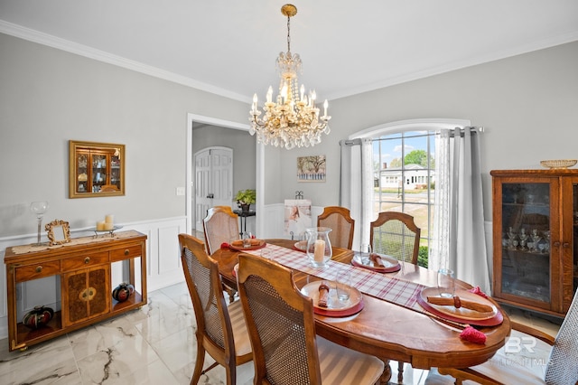 dining space featuring crown molding, a notable chandelier, wainscoting, and marble finish floor