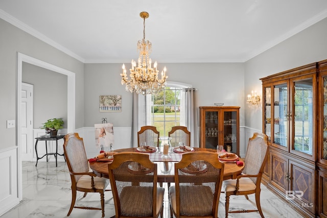dining area featuring crown molding, wainscoting, marble finish floor, and a chandelier