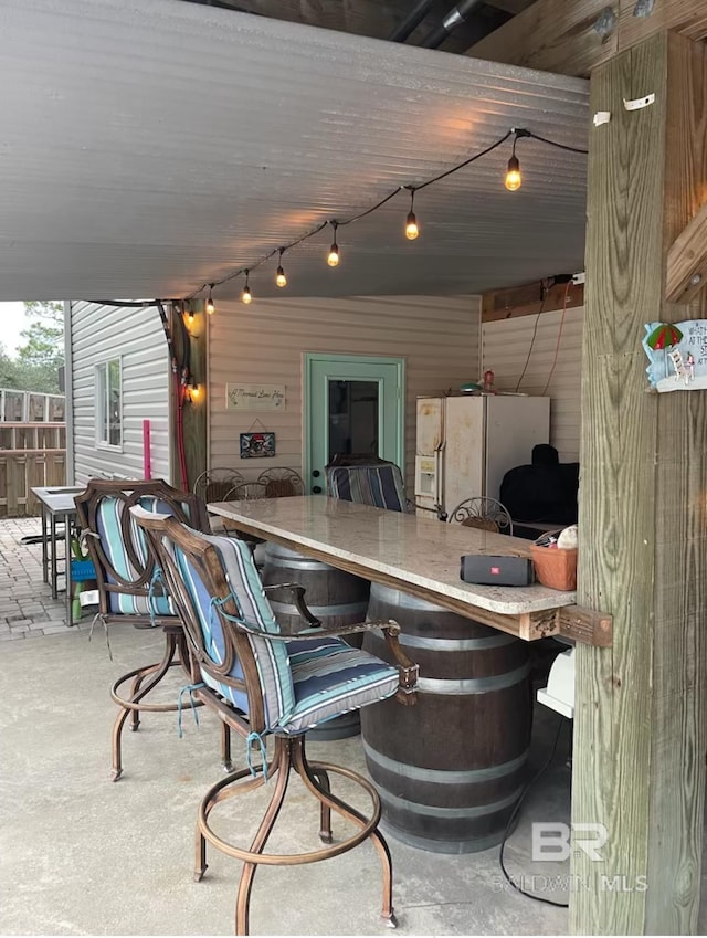view of patio featuring fence and outdoor dry bar