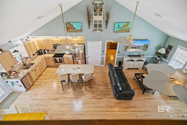 interior space with ceiling fan, high vaulted ceiling, light hardwood / wood-style floors, and sink