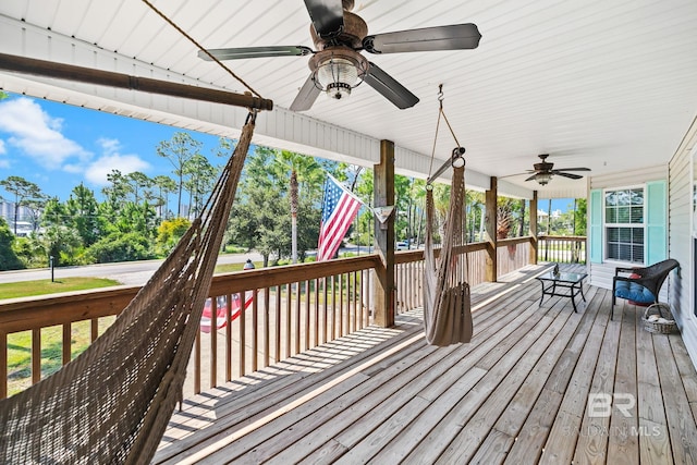 wooden terrace featuring covered porch and ceiling fan