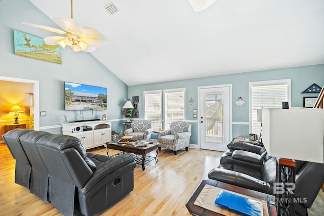 living room featuring visible vents, light wood-style floors, vaulted ceiling, ceiling fan, and baseboards