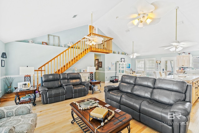 living area with visible vents, ceiling fan, stairway, and light wood finished floors