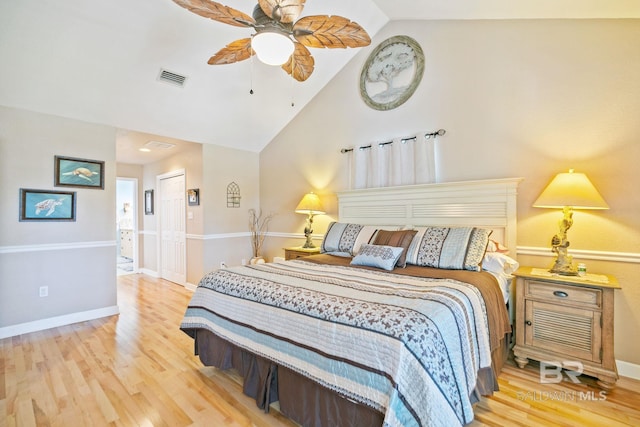 bedroom featuring baseboards, visible vents, lofted ceiling, wood finished floors, and a closet