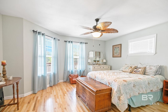 bedroom with light wood-type flooring, a ceiling fan, and baseboards
