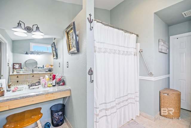 bathroom featuring a shower with shower curtain, tile patterned flooring, visible vents, and baseboards