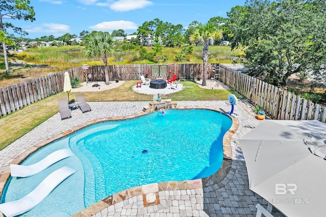 view of swimming pool with a patio area, a fenced backyard, and a fire pit
