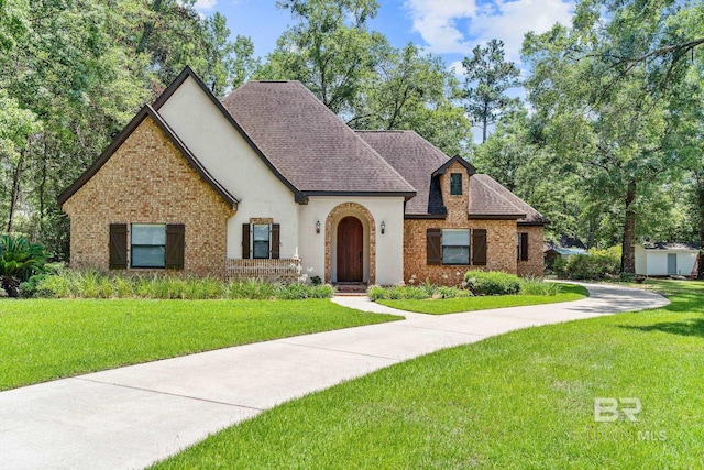 tudor home featuring a front lawn