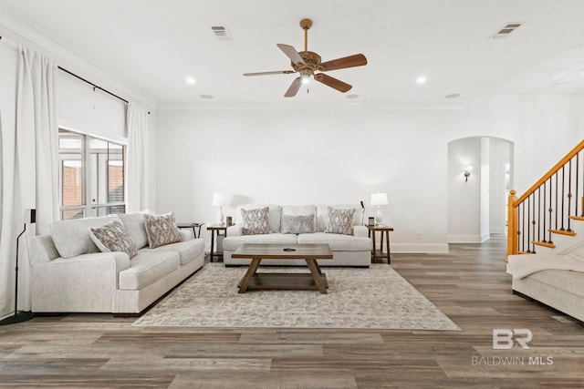 living room featuring hardwood / wood-style flooring, ceiling fan, and crown molding