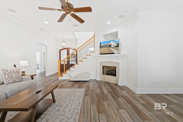 living room with a fireplace, hardwood / wood-style flooring, ceiling fan, and ornamental molding