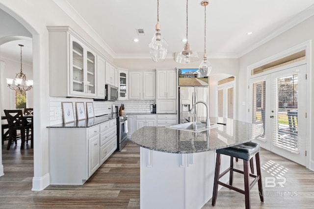 kitchen with white cabinets, sink, decorative backsplash, appliances with stainless steel finishes, and decorative light fixtures