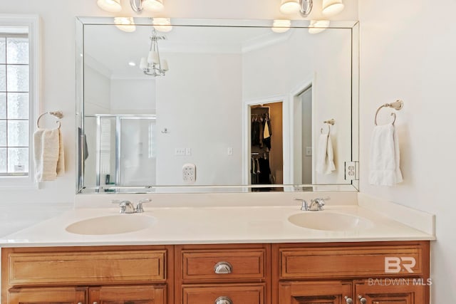 bathroom with crown molding, vanity, an enclosed shower, and an inviting chandelier